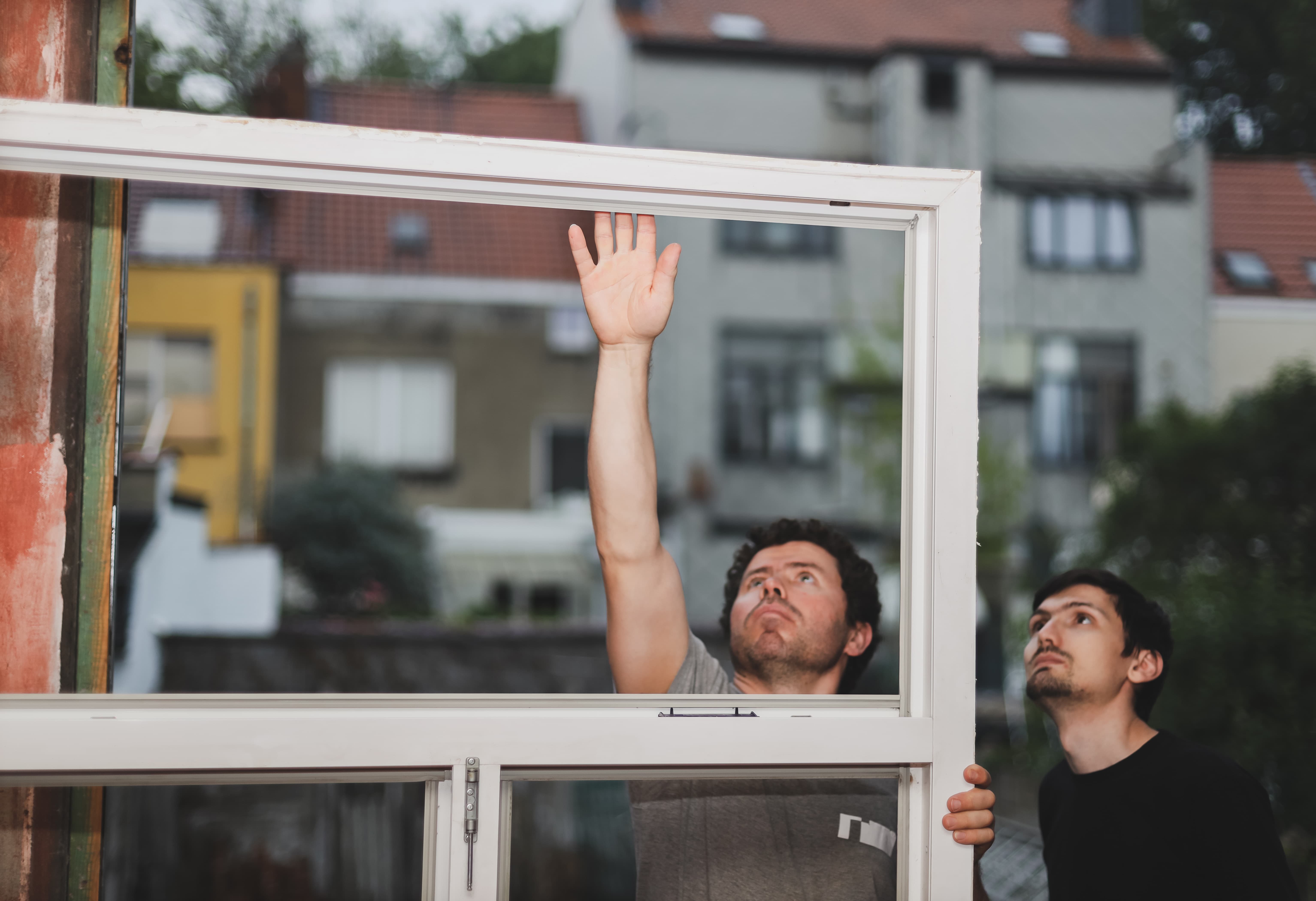 two caucasian male builders inspects dirty window frames 1 Lynnrich